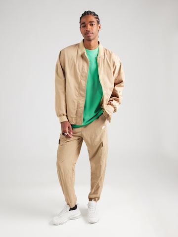 T-Shirt 'PREM ESSNTL' Nike Sportswear en vert