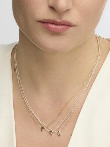 Luxenter Halsband 'T' i guld: framsida