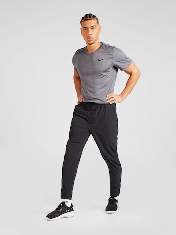 NIKE Zwężany krój Spodnie sportowe 'Unlimited' w kolorze czarny