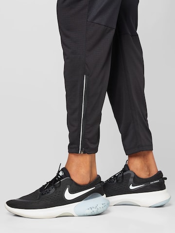 NIKE Tapered Urheiluhousut värissä musta