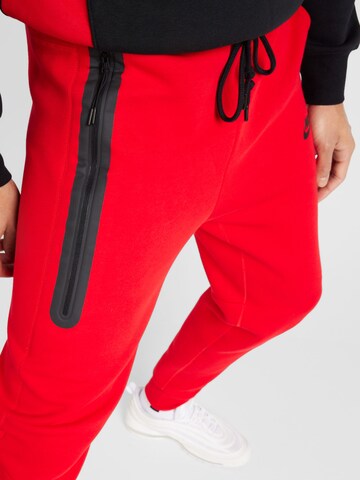 Nike Sportswear Zúžený Kalhoty 'TCH FLEECE' – červená