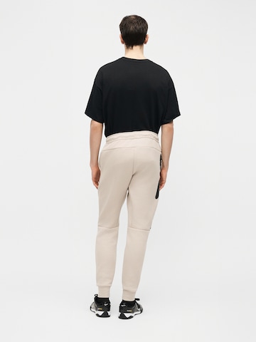 Nike Sportswear Zwężany krój Spodnie 'Tech Fleece' w kolorze beżowy